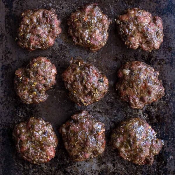 Homemade breakfast sausage patties on a sheet tray.