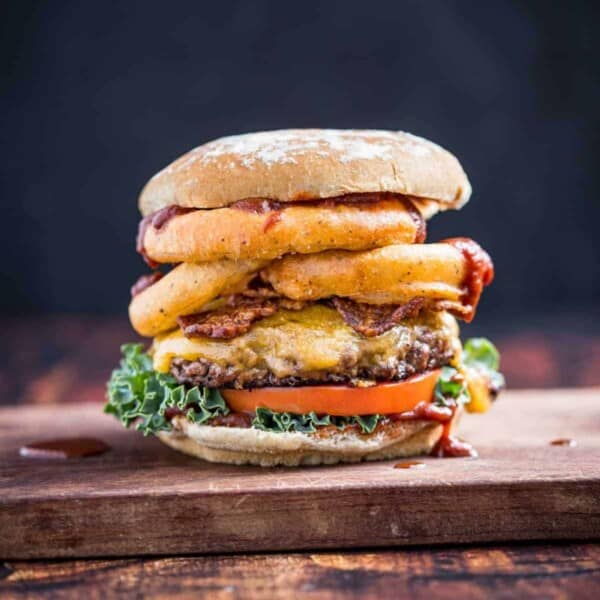Western Burger with onion rings on a cutting board.