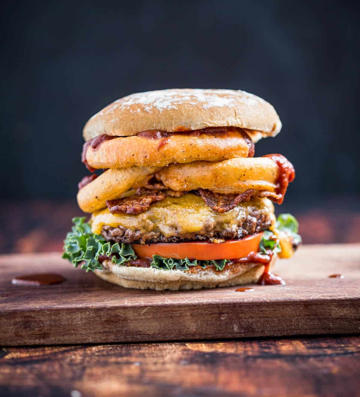 Western Cheeseburger with Onion Rings on a wood board