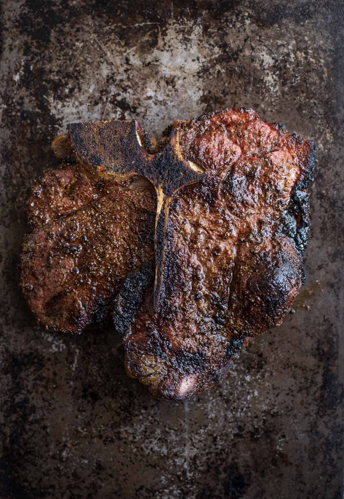 A grilled porterhouse steak resting on a platter