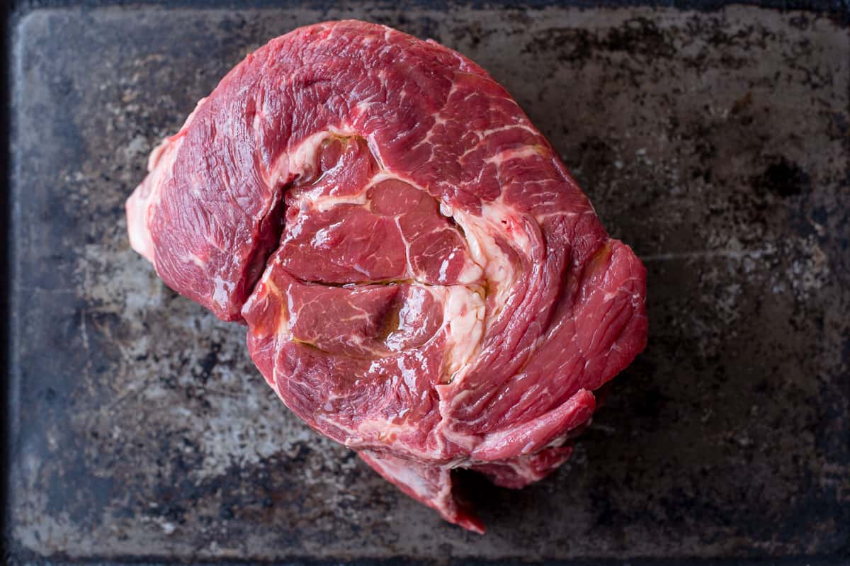 A raw Chuck Roast on a sheet pan