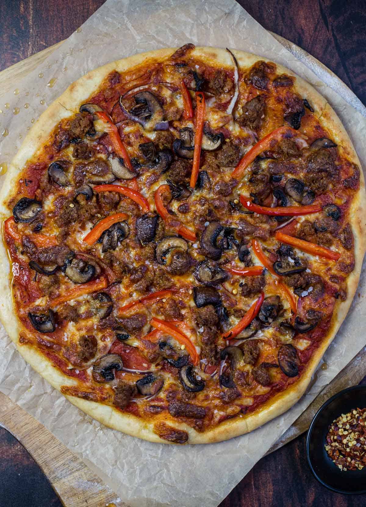 A Pellet Grilled Pizza Topped with Mushrooms, Sausage, and Peppers