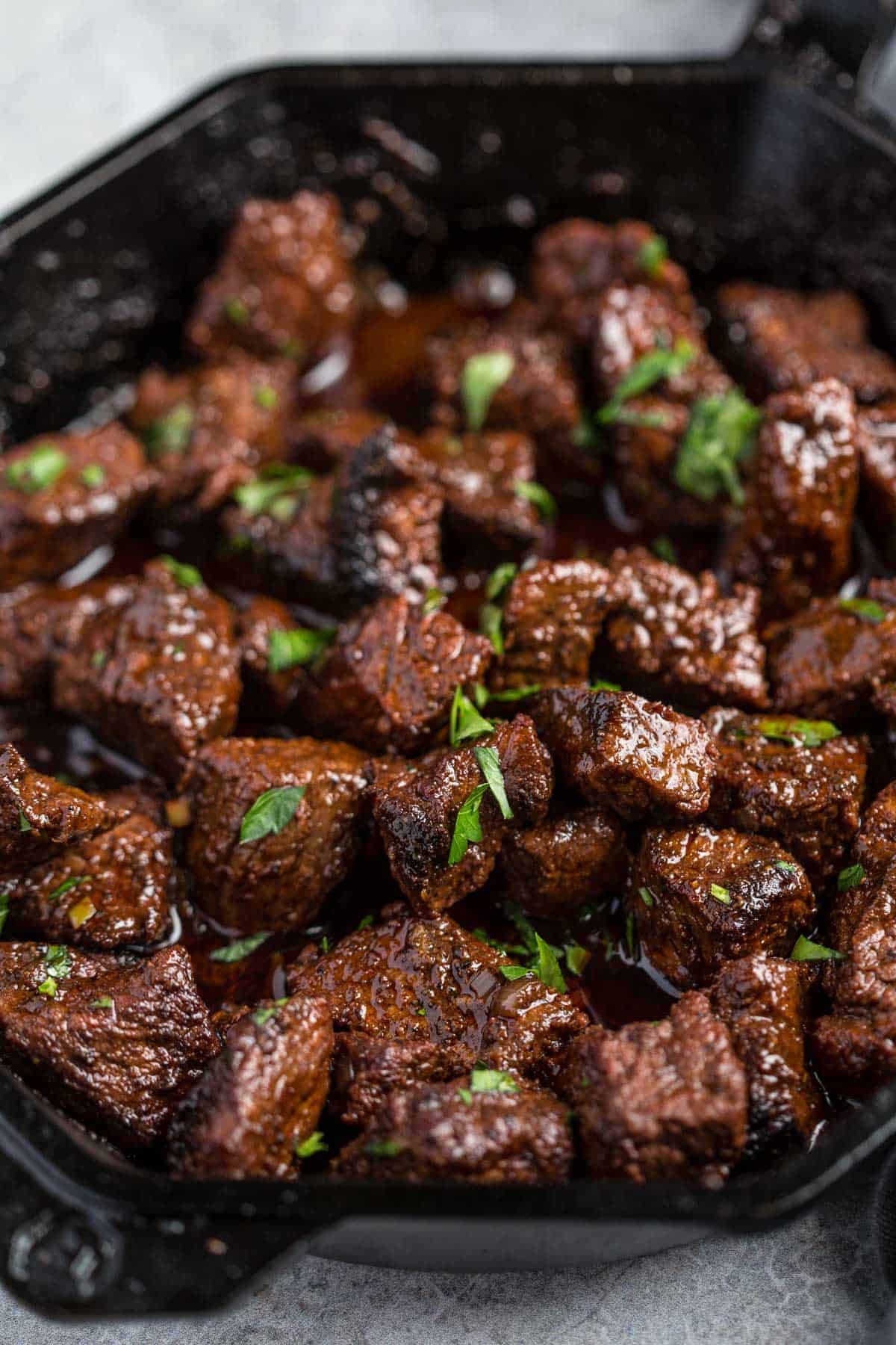 Grilled steak bites in a cast iron pan with a red wine pan sauce