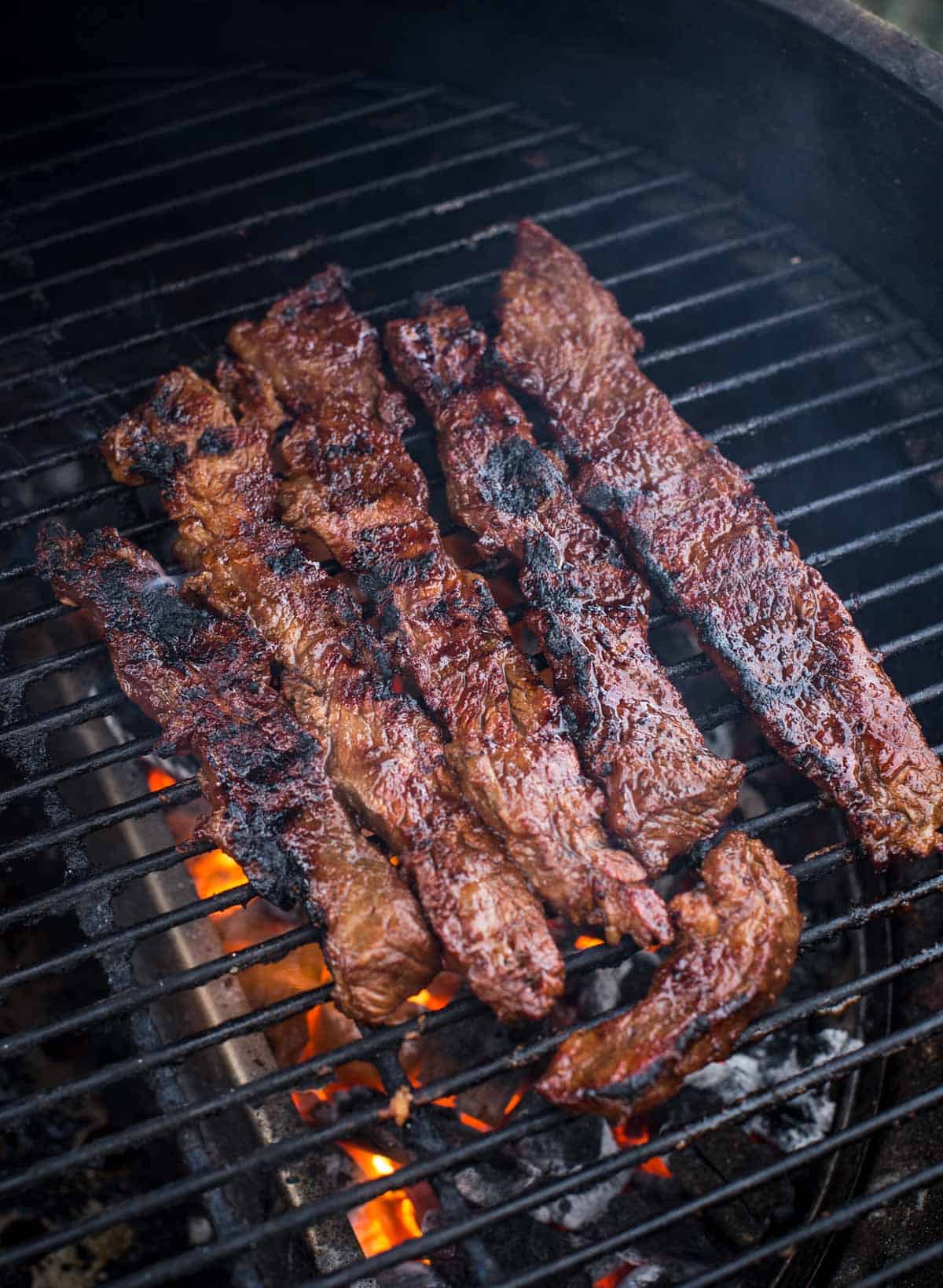 Flanken steak slices cooking on the grill