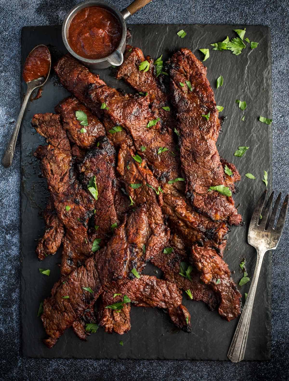 Marinated Beef Flanken Ribs sliced on a slate board