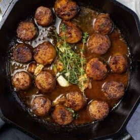 Grilled Scallops in a white wine pan sauce in cast iron pan.