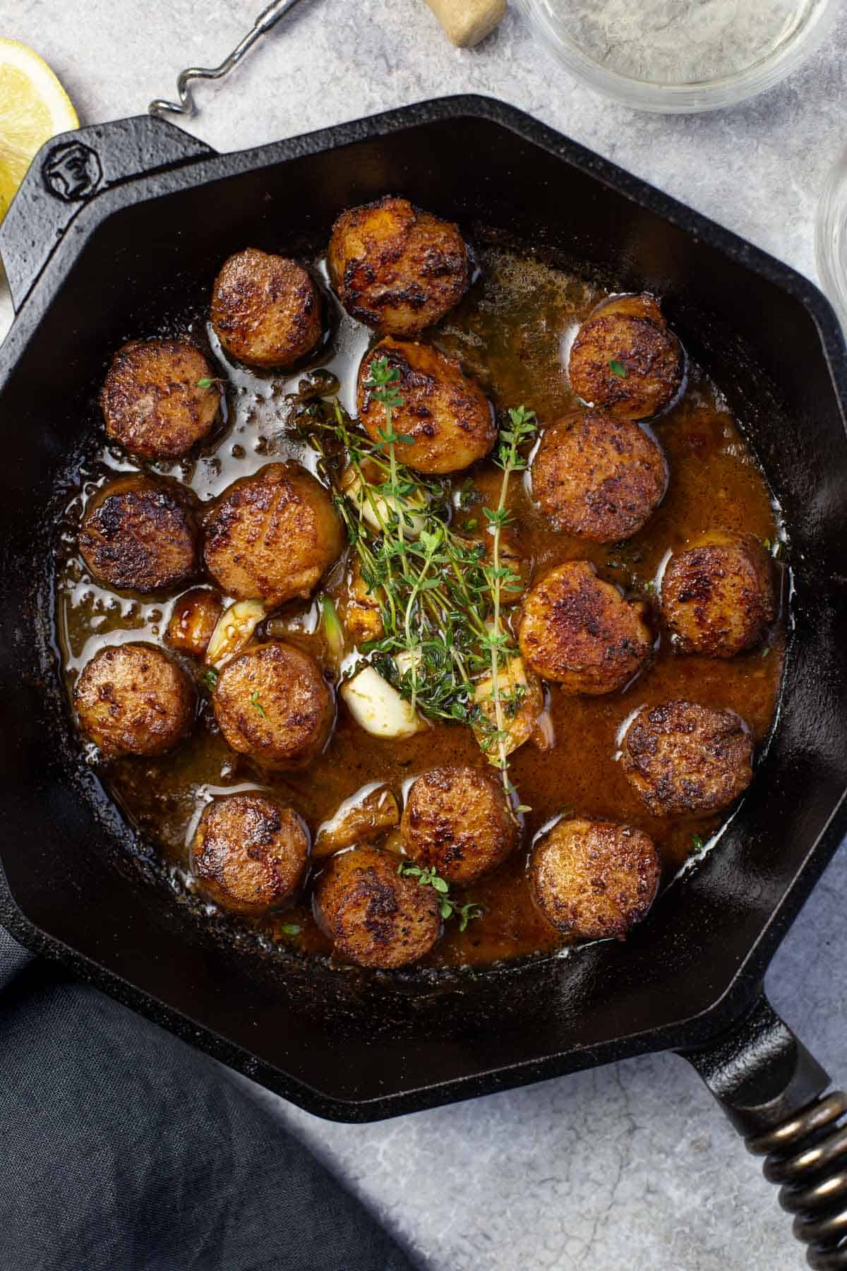 Grilled scallops with a white wine and butter sauce in a cast iron pan