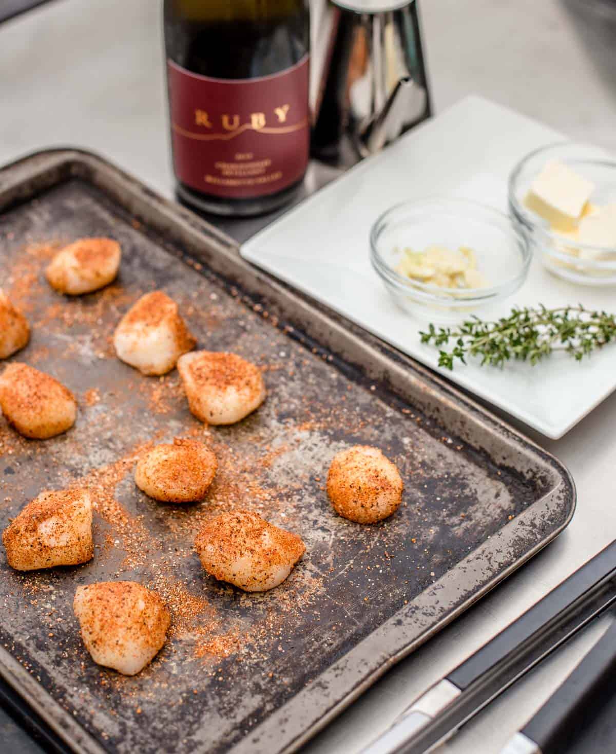 scallops on a sheet pan with seafood seasoning on them