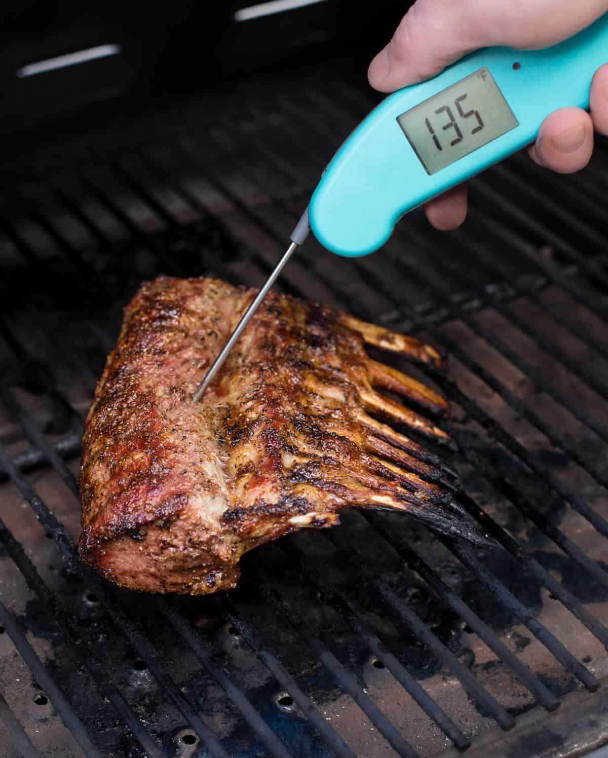 Taking temperature of medium rare lamb at 135 degrees F.