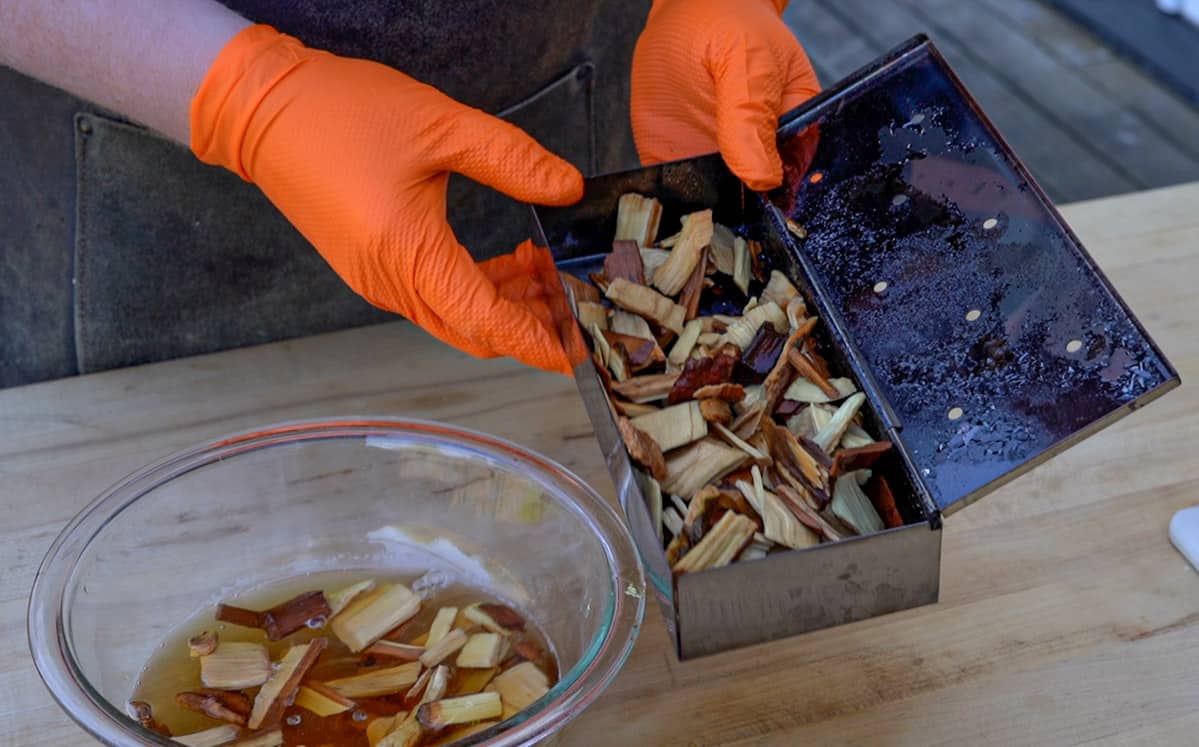 A smoker box filled with soaked wood chips