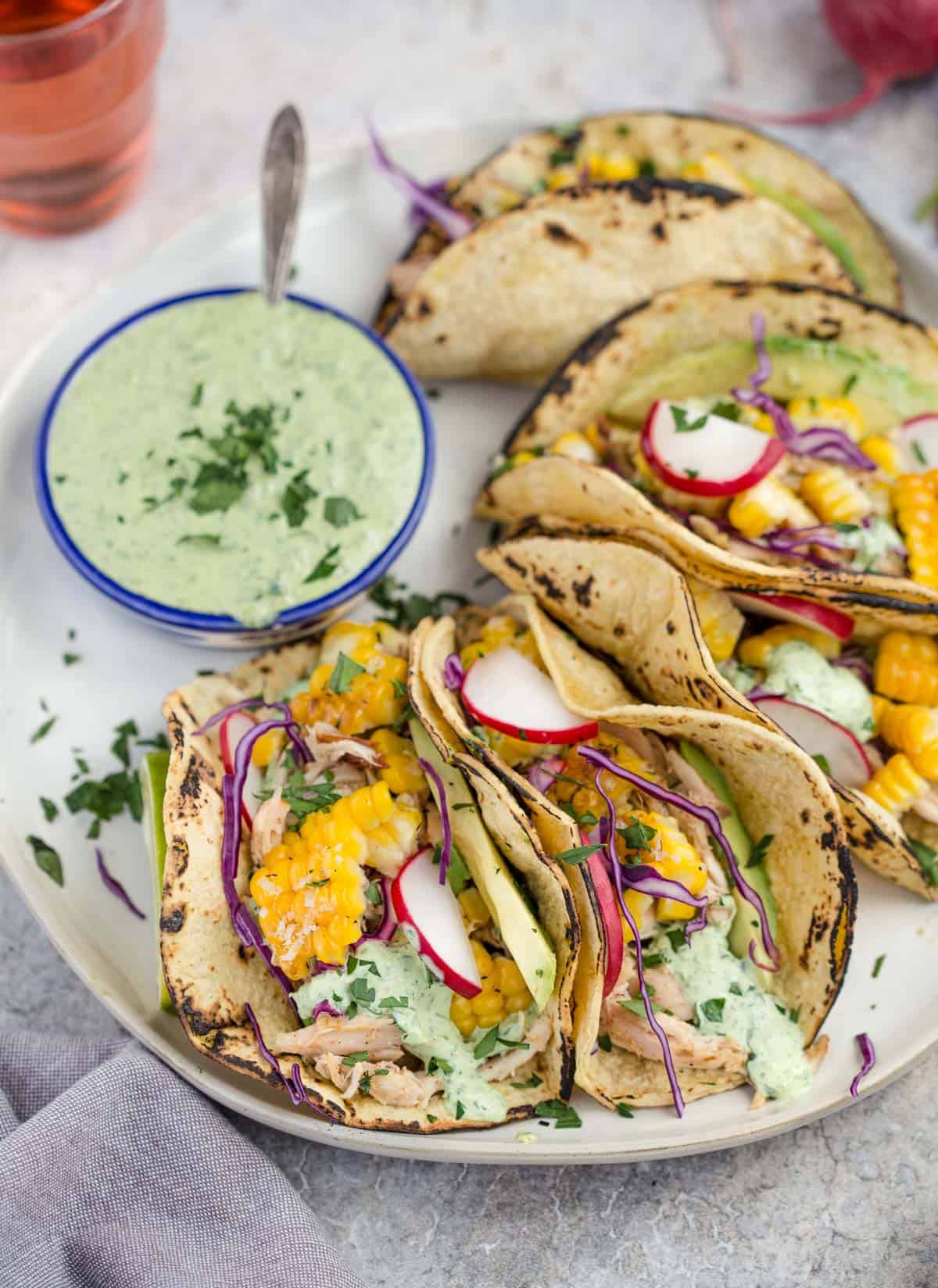 Griilled Corn tacos on a platter with sauce.