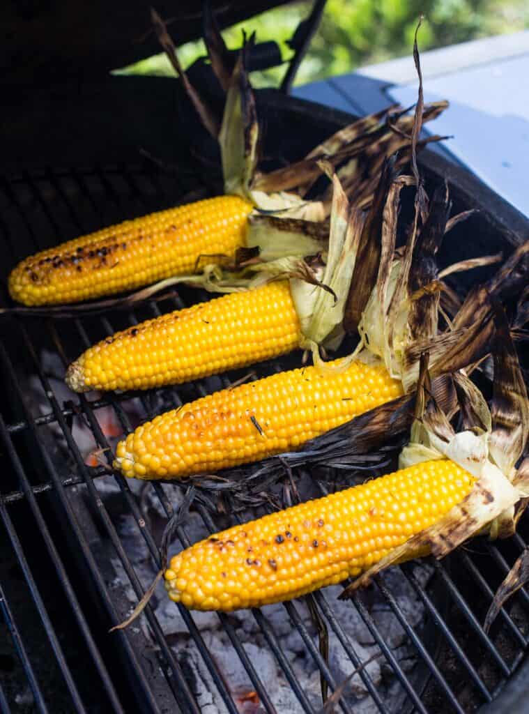 Grilled Corn with husks removed on a grill.