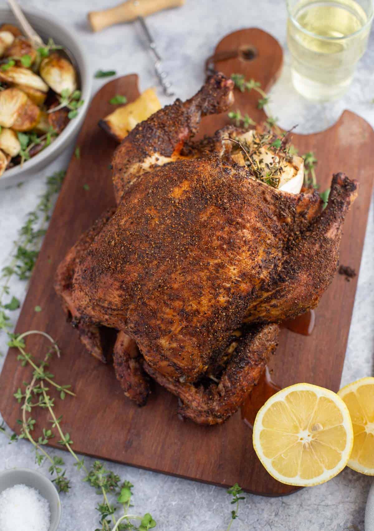 A whole pellet grill roasted chicken on a cutting board