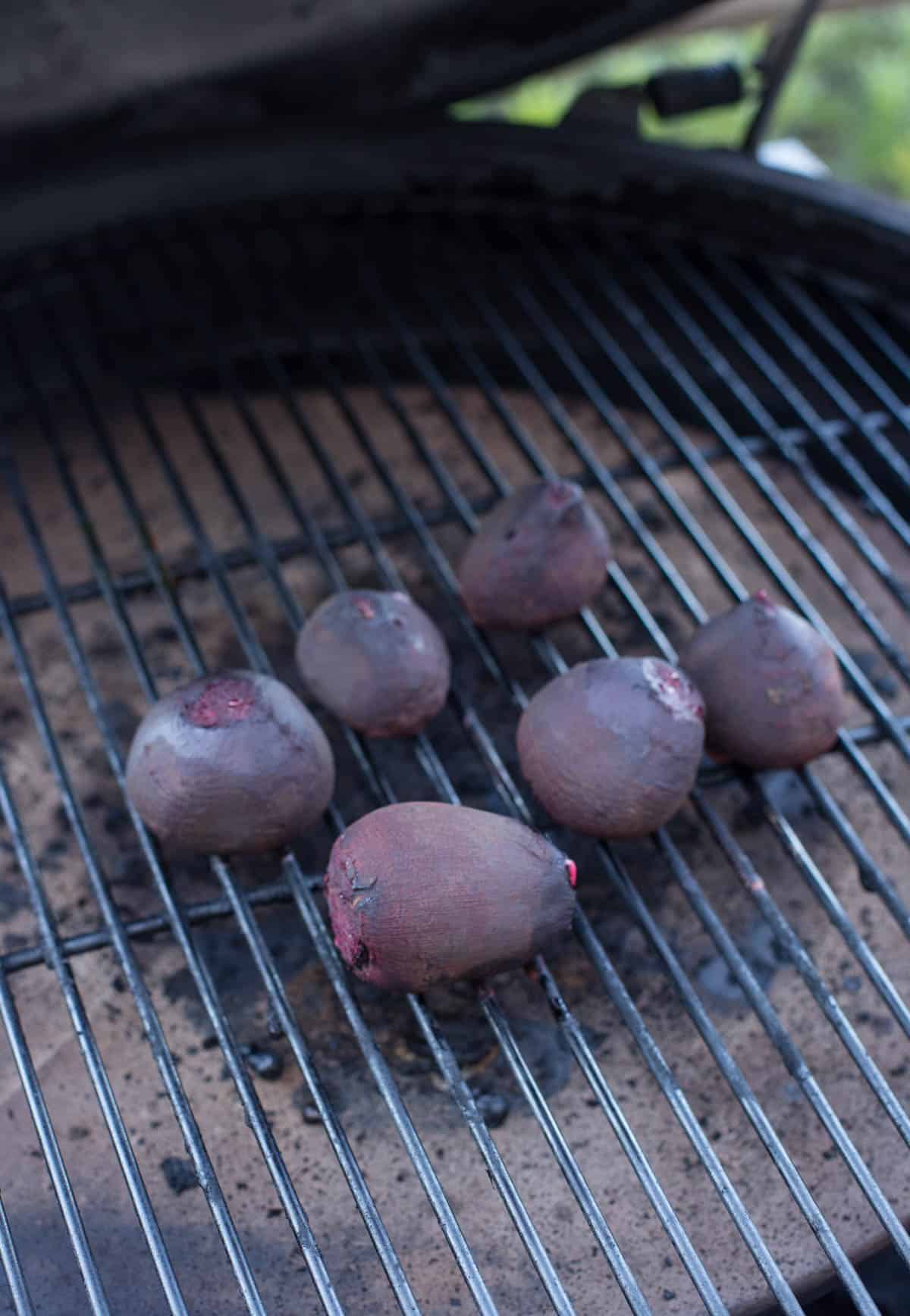 6 red beets smoking on a grill