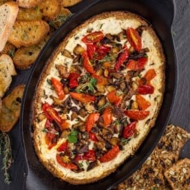 Lodge cast iron baking dish with baked goat cheese, mushrooms, and crostini.