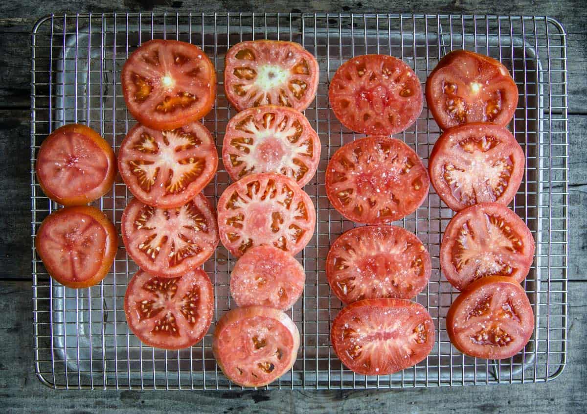 Fresh slices of summer tomatoes on a drying rack