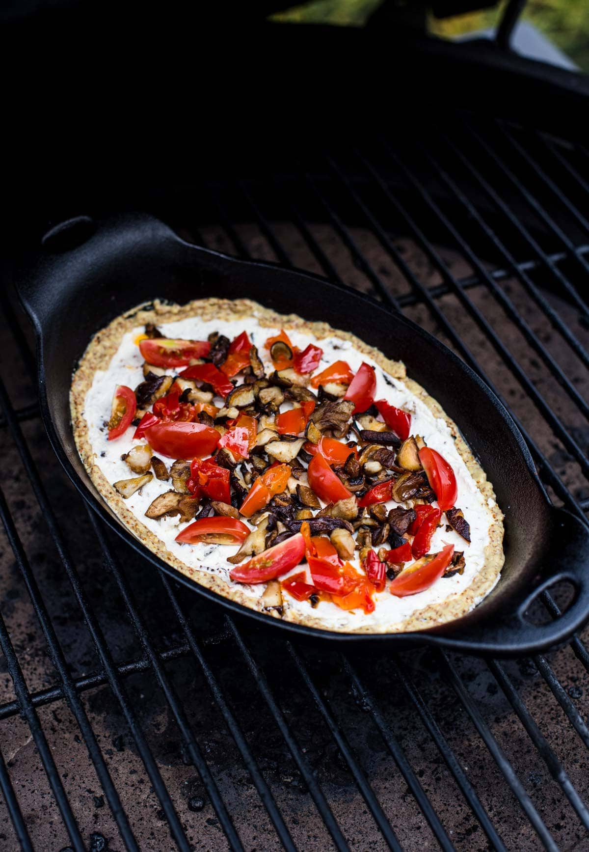 Goat Cheese Dip in a cast iron pan cooking on the grill