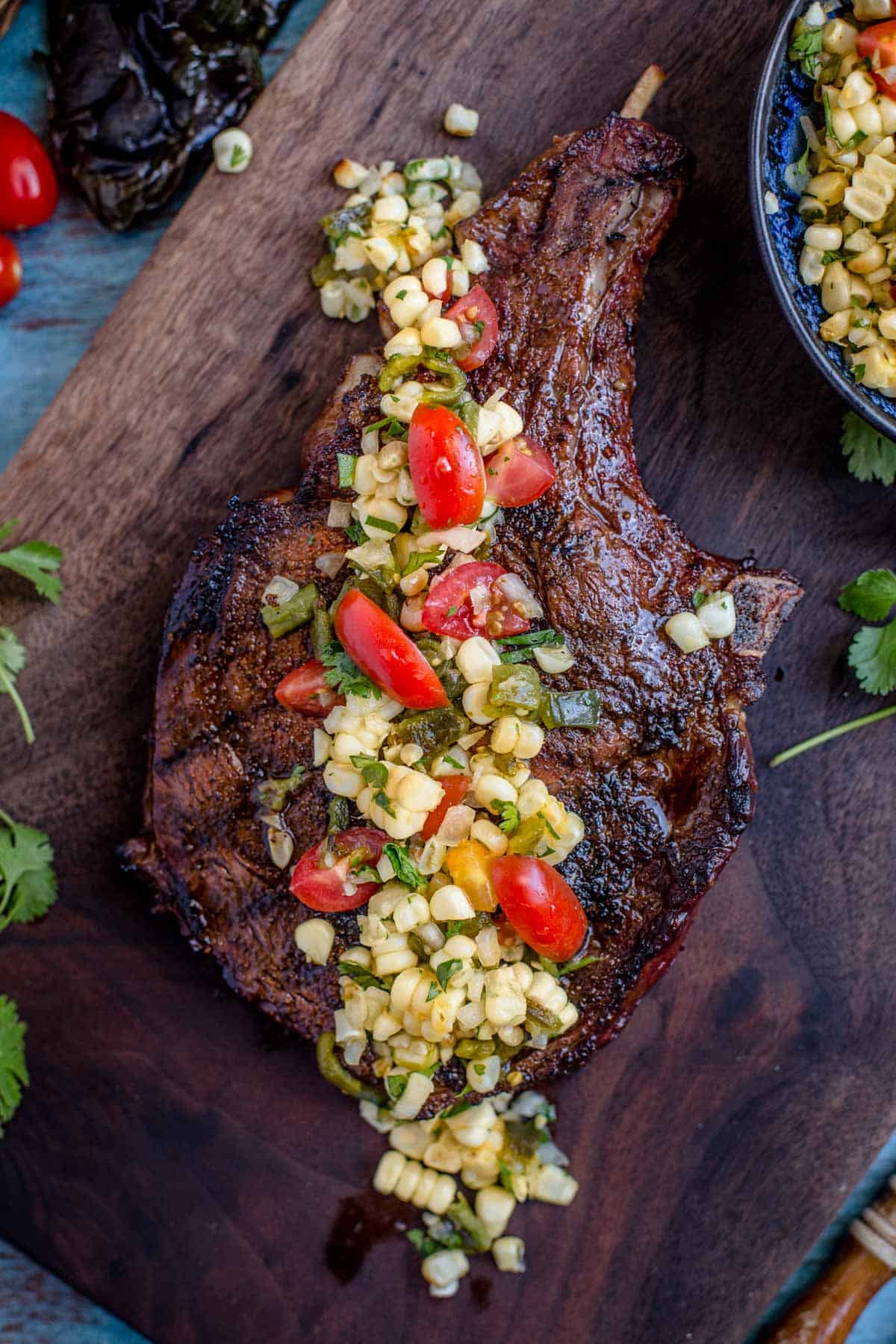 A grilled steak topped with a roasted poblano and corn salsa