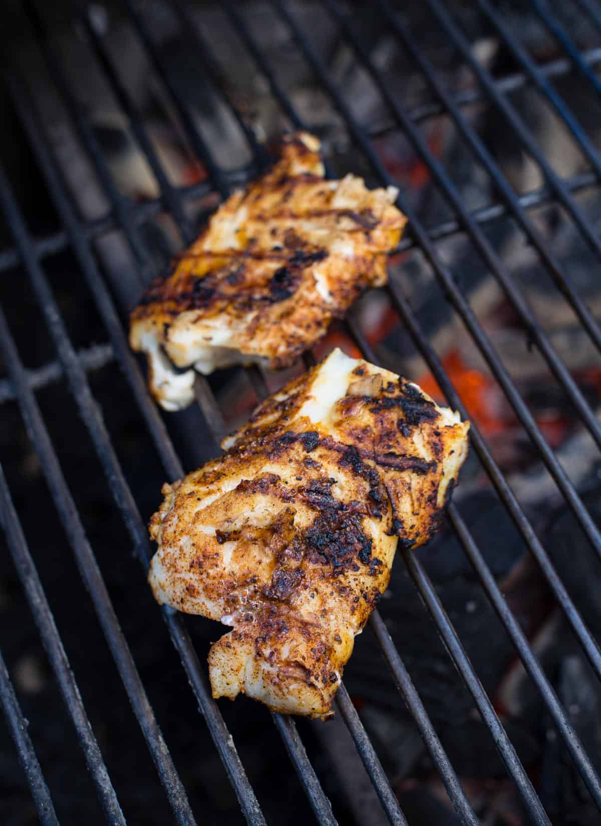 Grilling 2 filets of cod on a hot grill