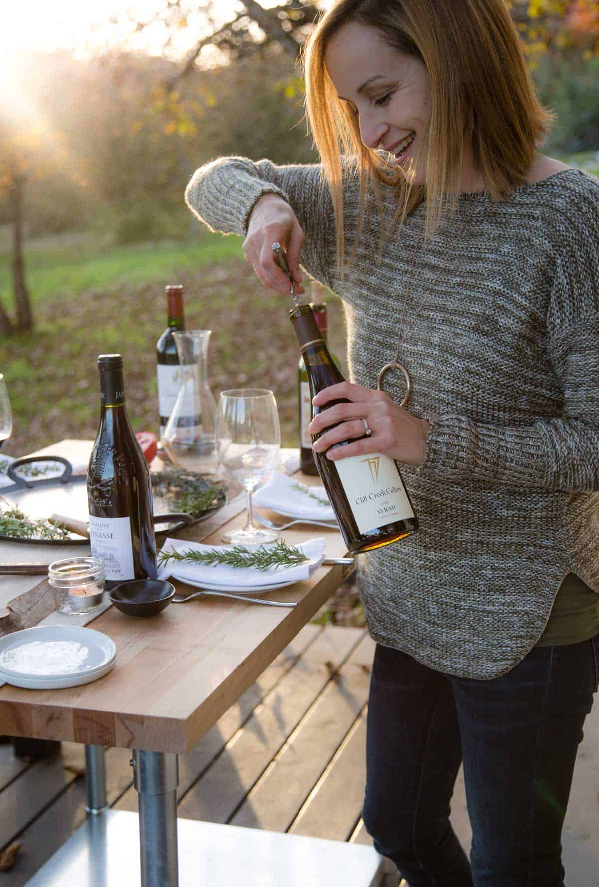 Woman opening a bottle of Syrah Wine