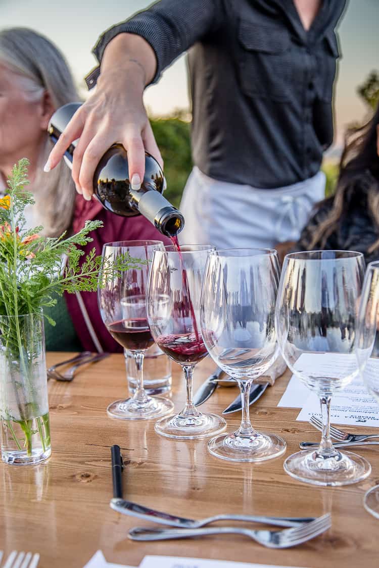 Pouring cabernet franc wine into glasses