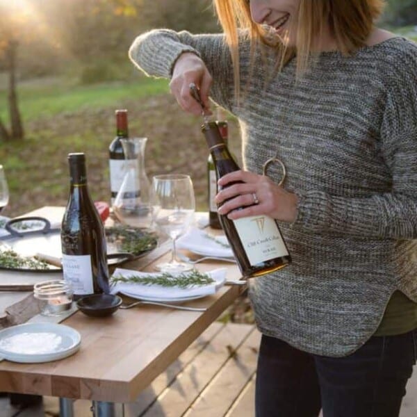 mary cressler opening a bottle of wine