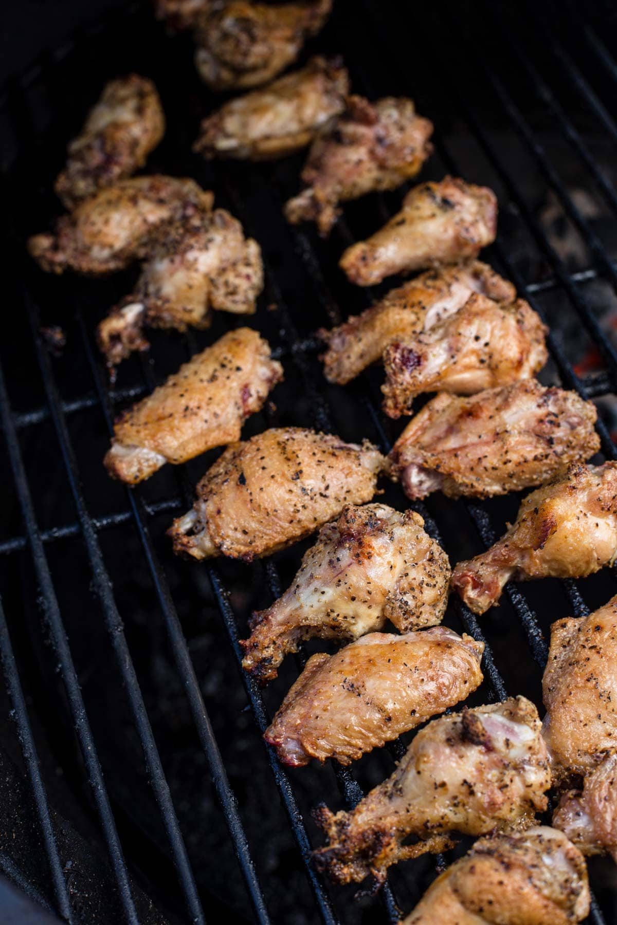 Chicken wings cooking on the grill.
