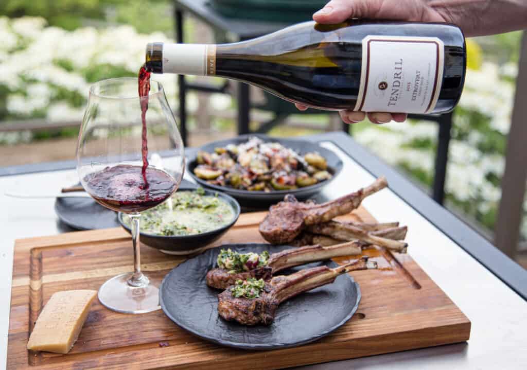 Pouring wine in a glass with lamb.