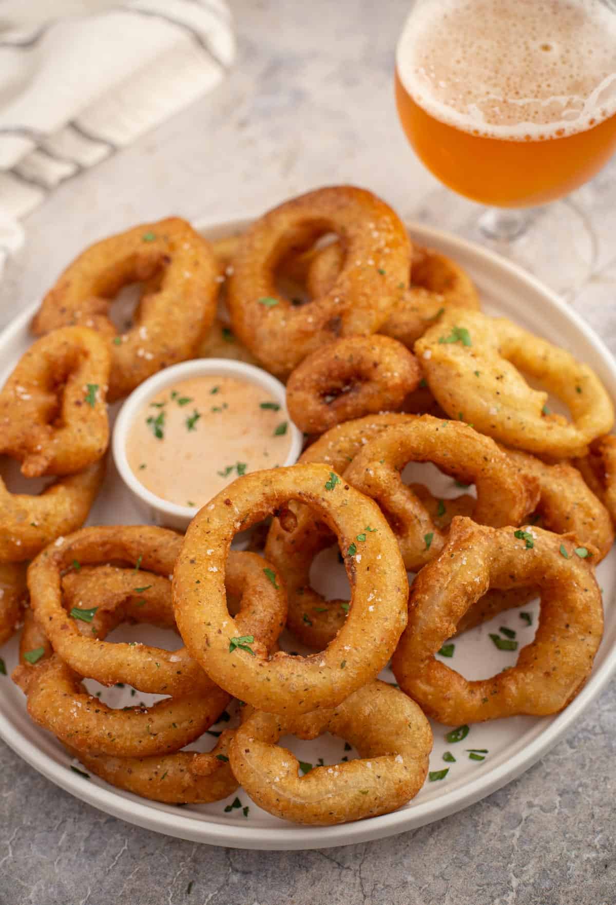 A platter of smoked onion rings and a glass of beer