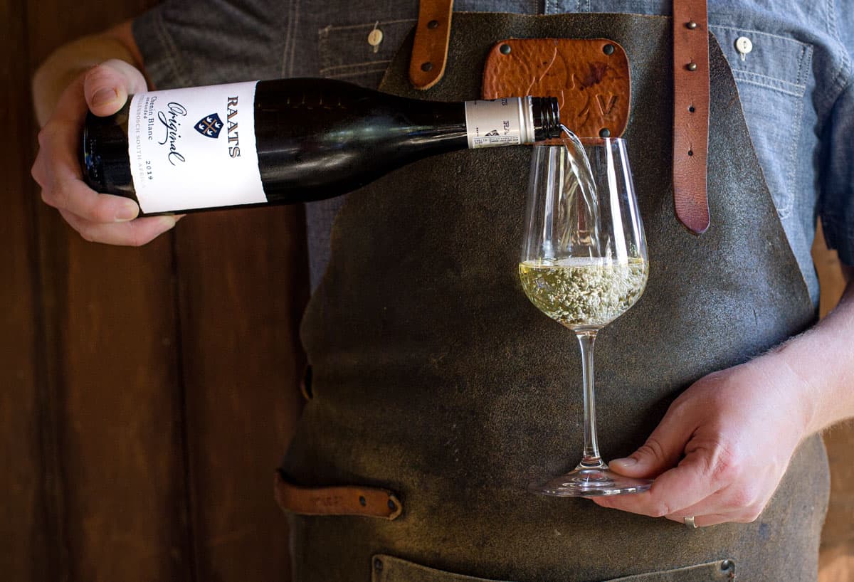 Pouring a glass of Chenin Blanc wine into a wine stem