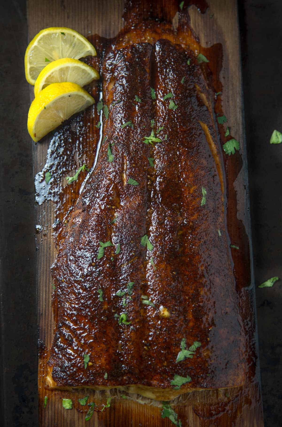 Cedar Plank Grilled Salmon with Maple Chipotle Glaze resting on a cedar plank