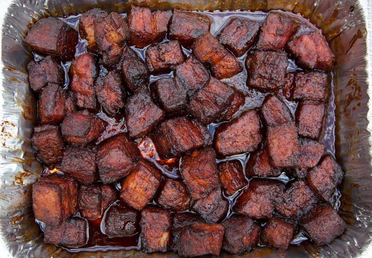 Smoked Pork Belly Burnt ends fully cooked in an aluminum pan 