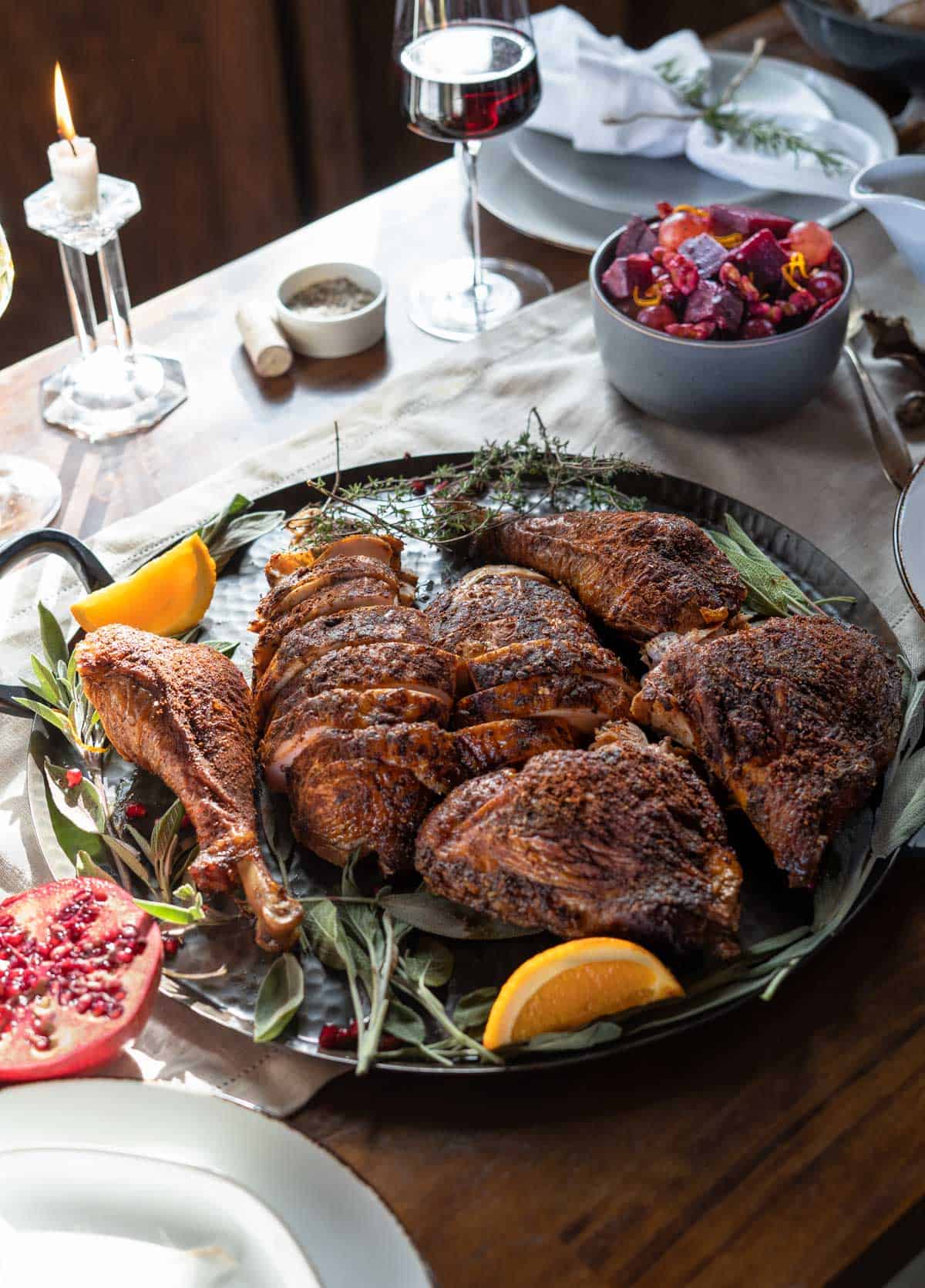 A Smoked Turkey on a table with other Thanksgiving side dishes in a lovely holiday tablescape 