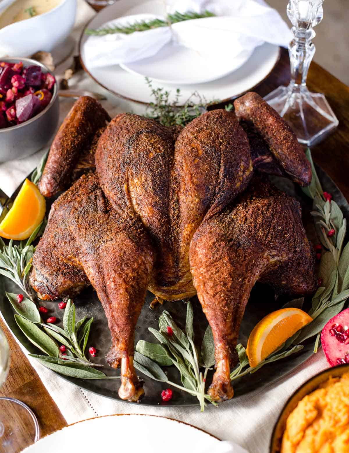 A Smoked Spatchcocked Turkey on a platter in a Holiday tablescape 