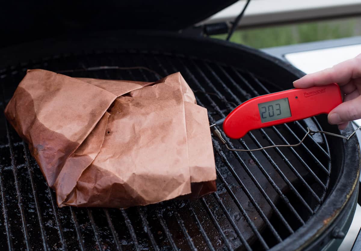 Taking the temperature of a smoked brisket flat with a thermapen digital thermometer