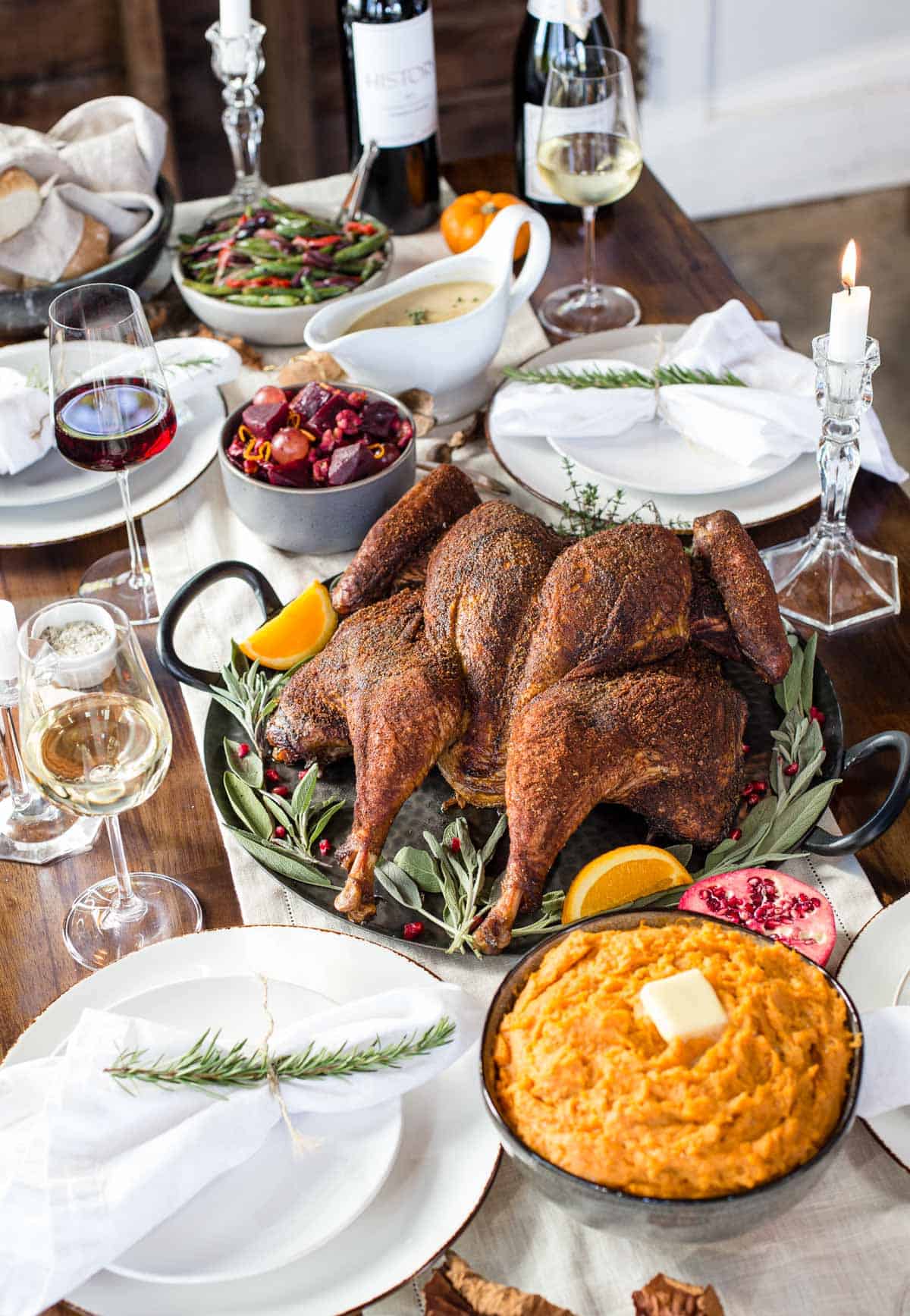 A spatchcocked turkey on a thanksgiving tablescape with side dishes