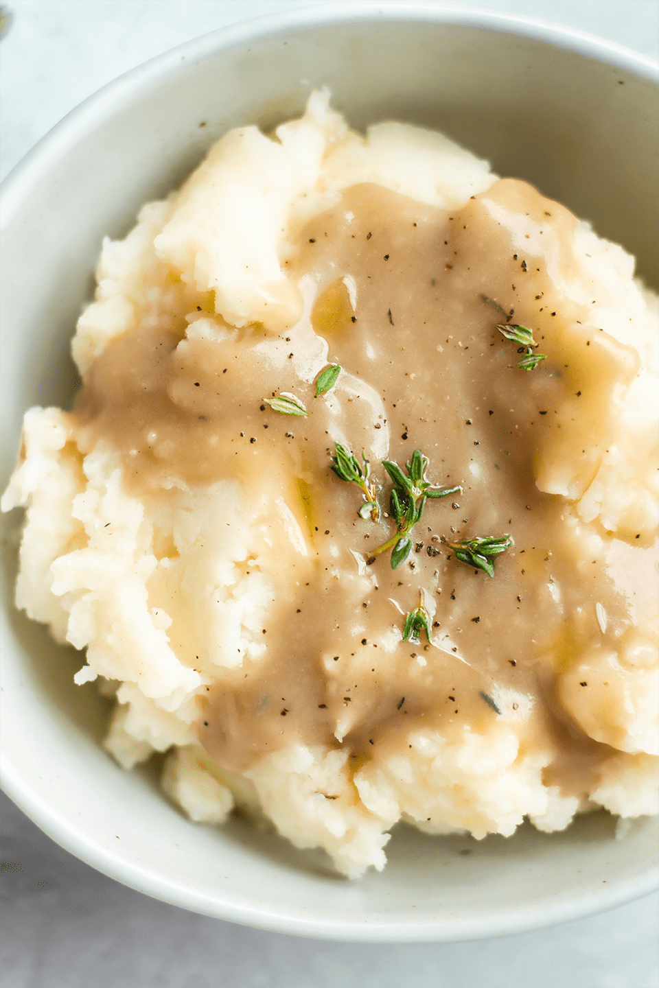 Smoked turkey bourbon gravy close up over mashed potatoes.