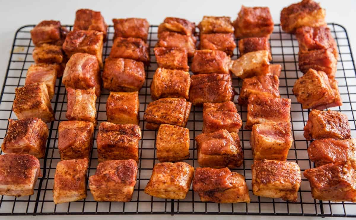 raw pieces of pork belly on a wire rack 