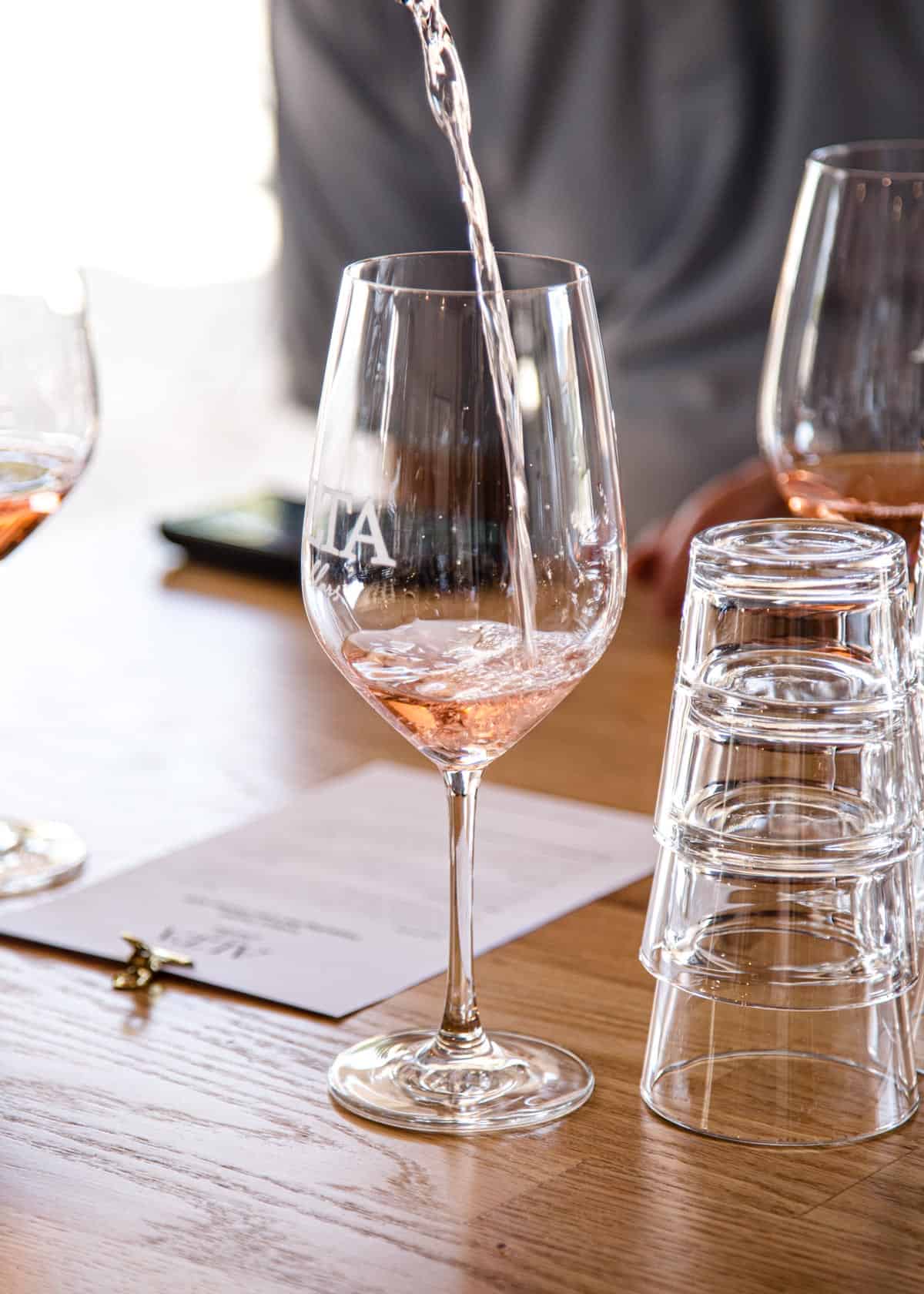 Pouring a glass of Rosé into a wine glass