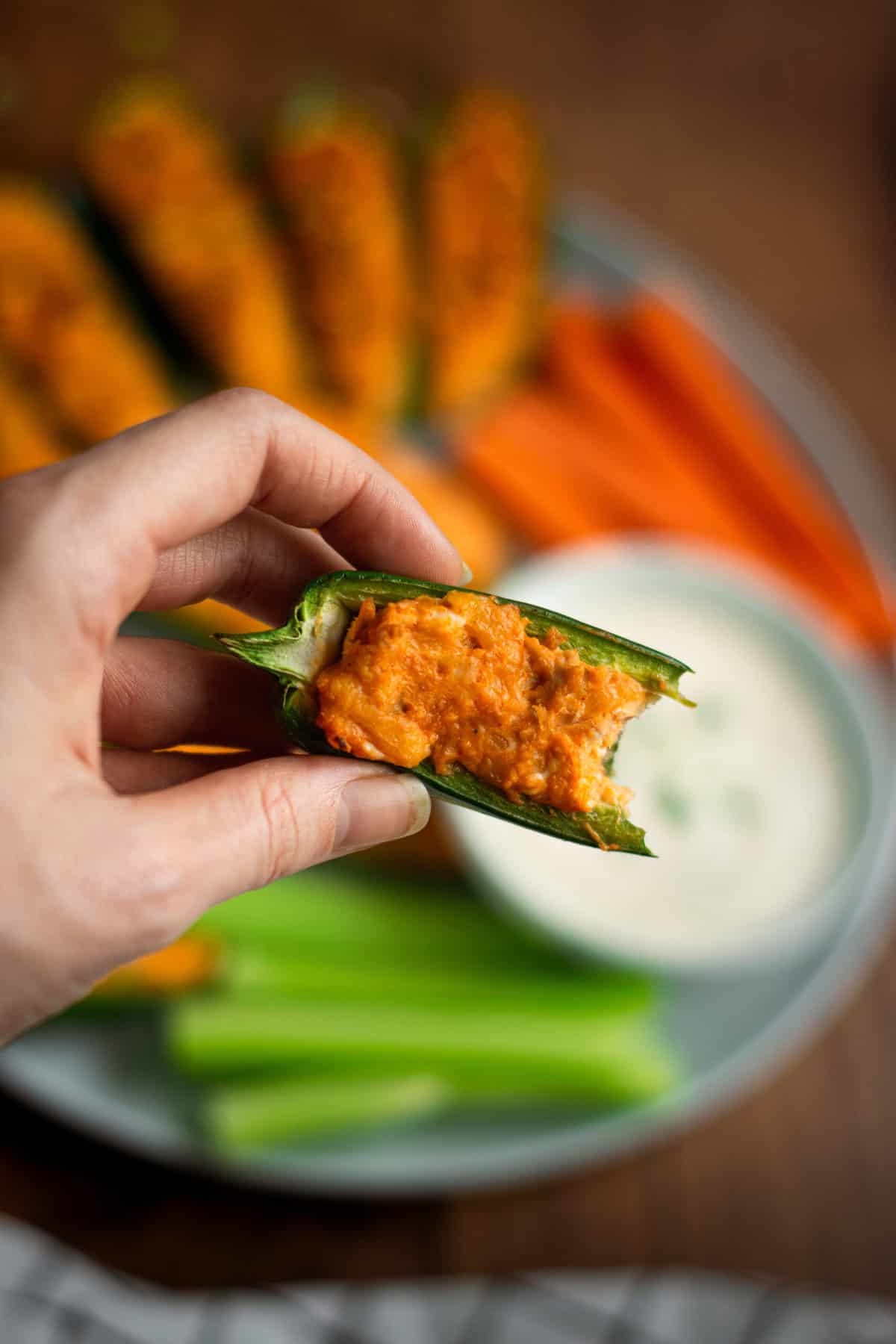 a bite shot of grilled buffalo chicken jalapeño poppers