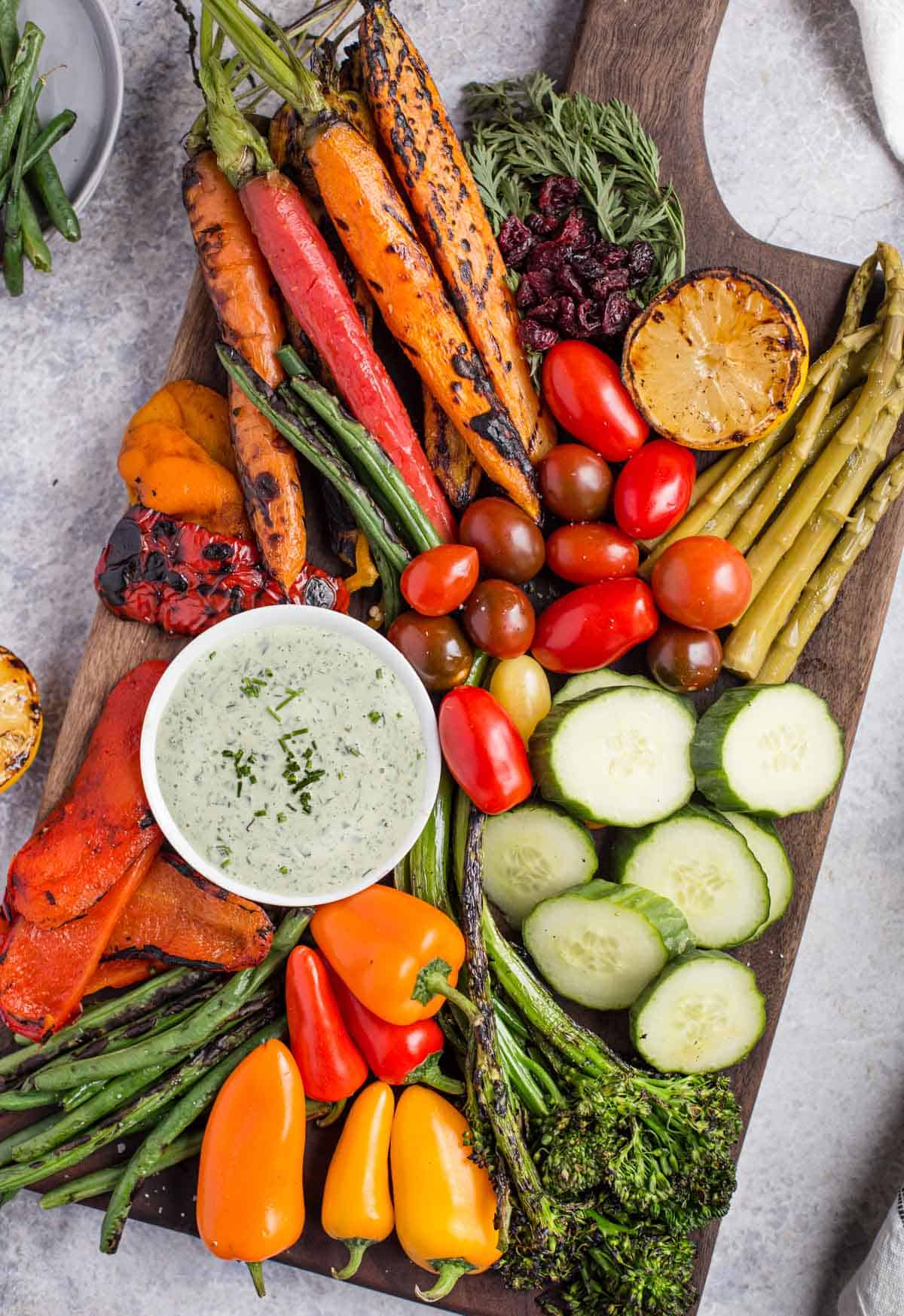 A Crudités Platter on a large cutting board with a tarragon dipping sauce
