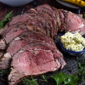 Grilled Prime Rib on a platter with herb compound butter
