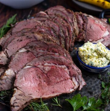 Grilled Prime Rib on a platter with herb compound butter