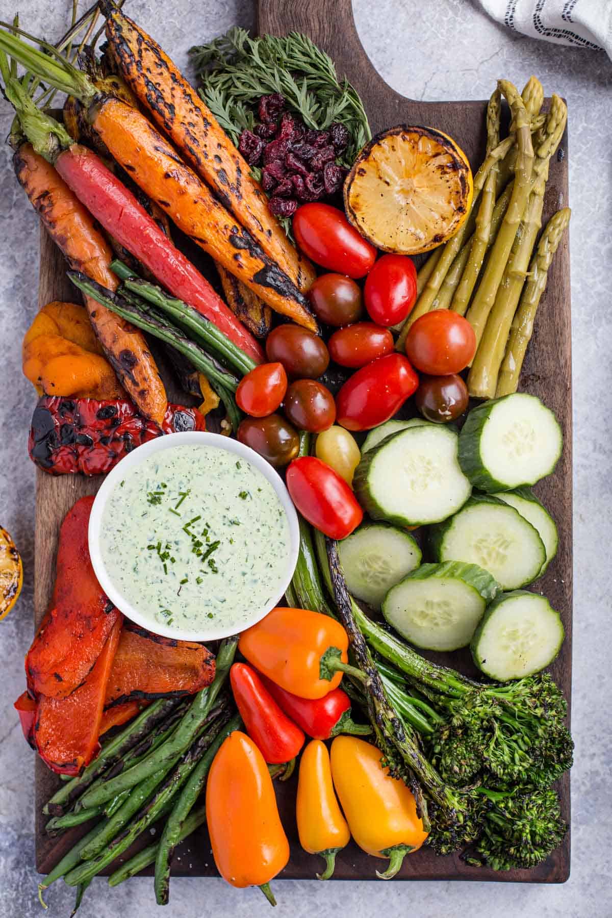 Vegetables spread out on a cutting board to create a beautiful Crudités Platter with a tarragon dipping sauce 