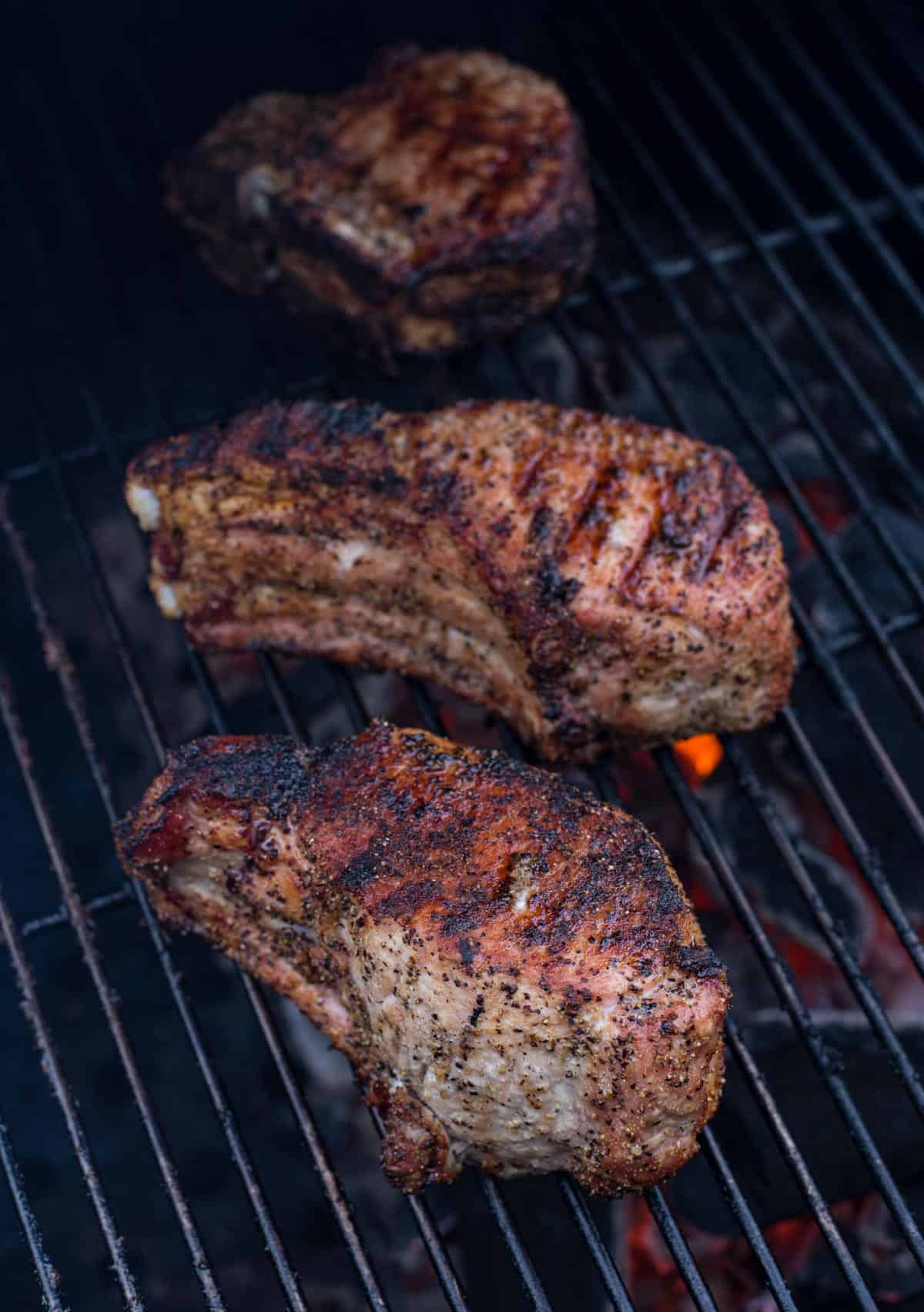 2 large pork chops cooking on the grill