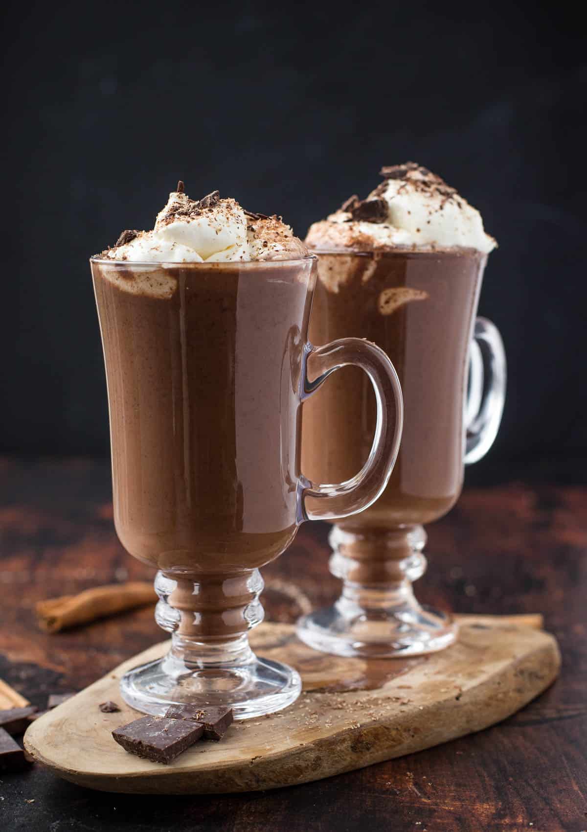 Two mugs filled with smoked hot chocolate topped with smoked whipped cream