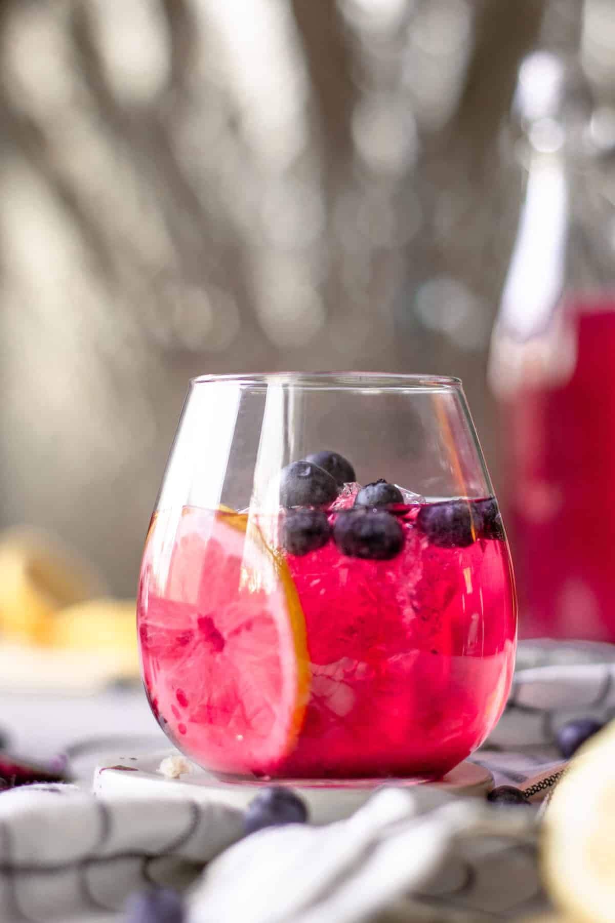 Blueberry Gin and Lemonade Cocktail in a stemless wine glass.