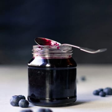 small jar of blueberry simple syrup with spoon