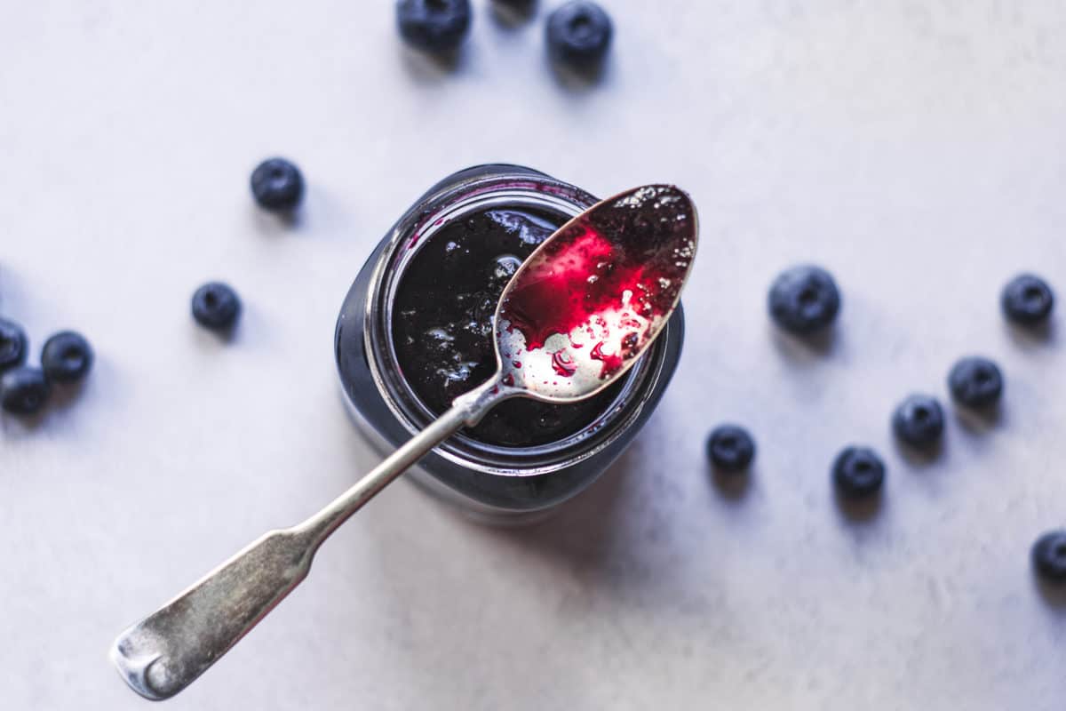 Top down view of blueberry simple syrup in a mason jar.
