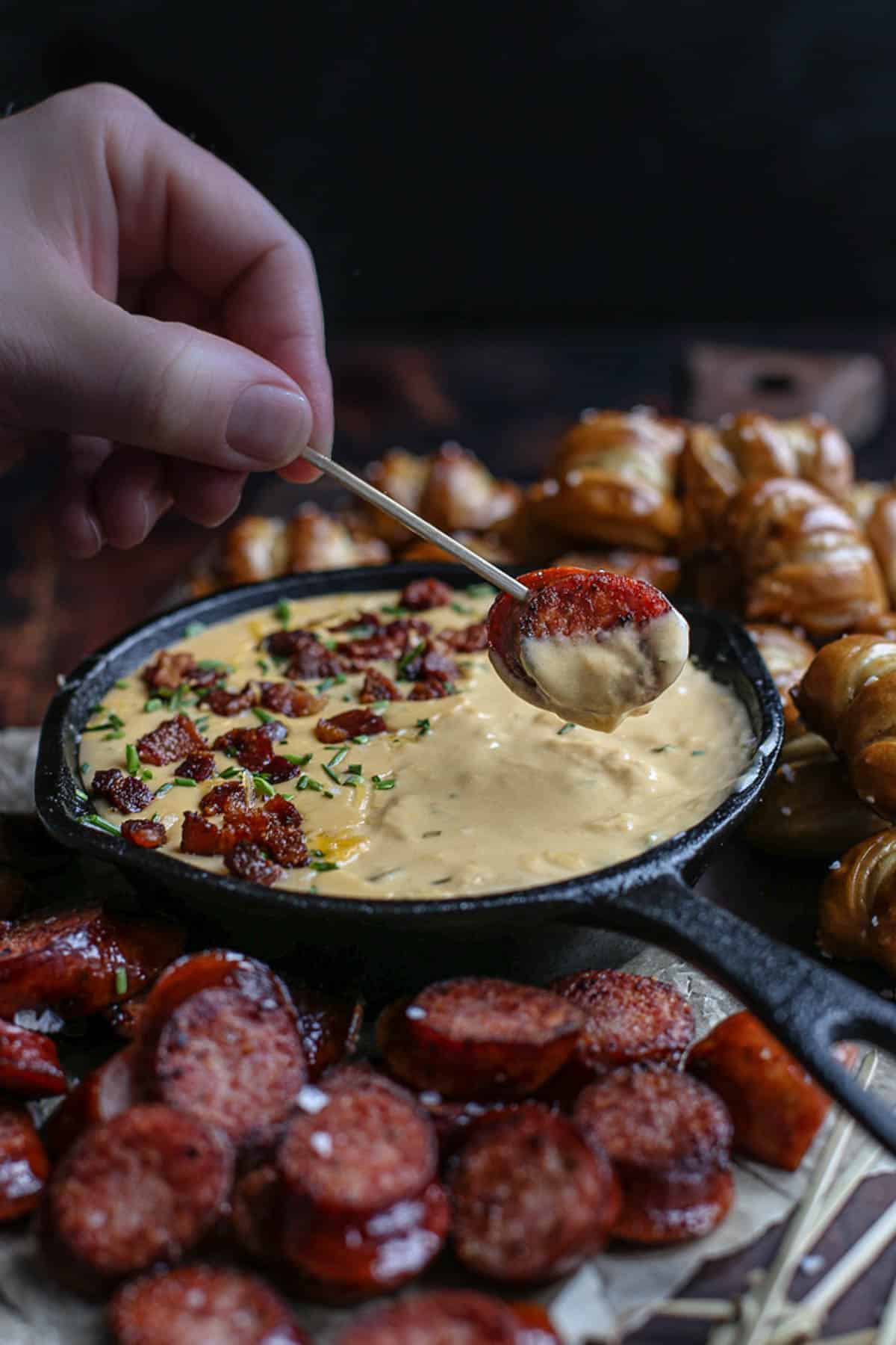 dipping a sausage in beer cheese